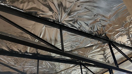 A ceiling covered in radiant barrier. It has a shiny surface like aluminum foil.