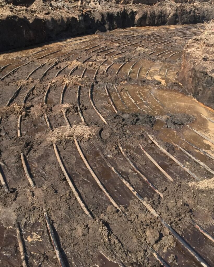 A dug-out section of dirt with semi-buried geothermal piping.