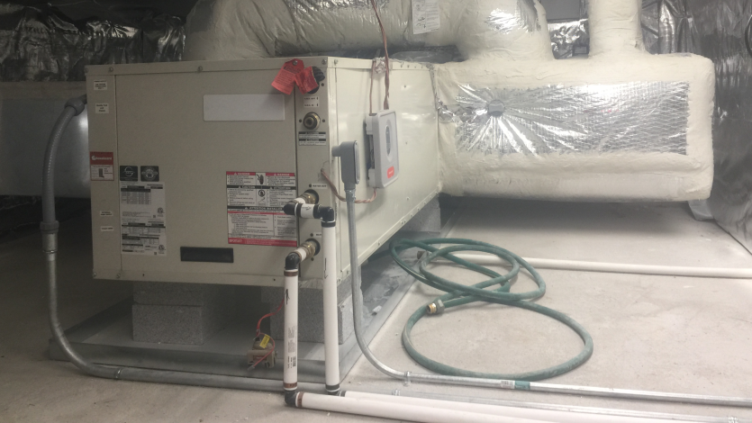 A four ton geothermal unit. It looks like a large L-shaped metal box with ducts going in and out.