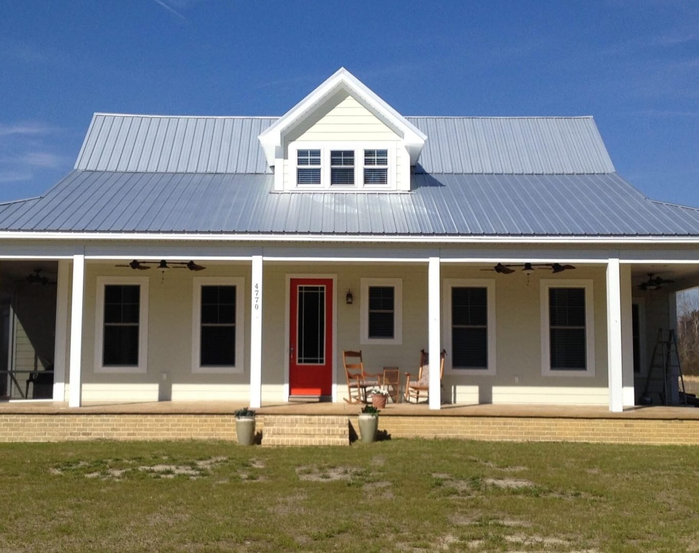 A long South Carolina house with a porch, a metal roof, and a dormer window. Though it is not obvious on the surface, it has concrete walls beneath and is built using a variety of green building techniques.