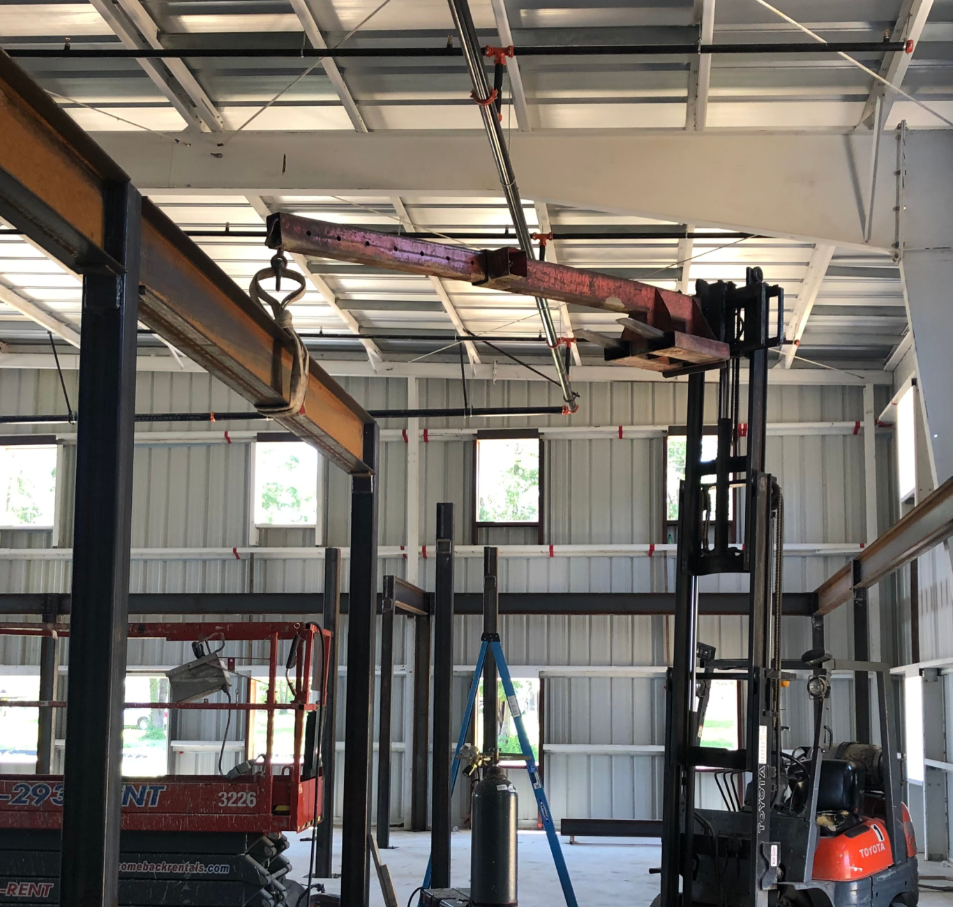 A commercial construction site with a variety of tools and machines sitting dormant before their next use in a building with metal on its walls and floors. Built by Buildgreen Industries in South Carolina.