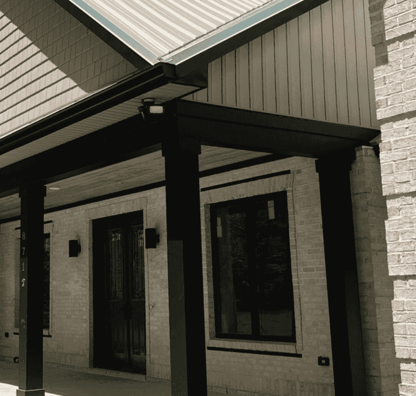 A stone-and-vinyl house with a porch overhang. Beneath the surface, this energy-saving house is filled with features such as radiant barrier and spray foam insulation.